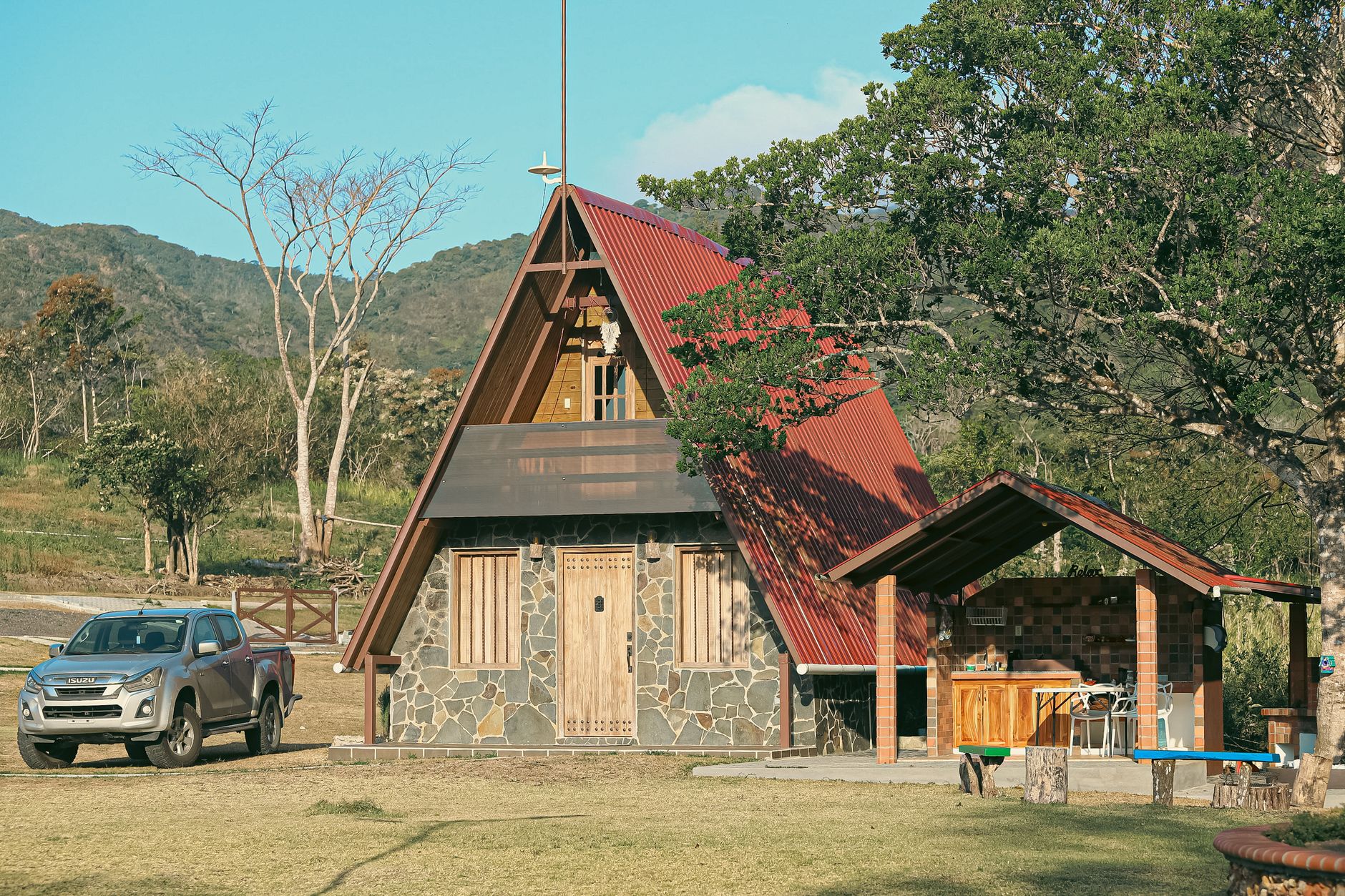 A charming A-frame cabin with a red roof nestled in the lush hills of western Panamá Oeste — the kind of highland retreat that defines life near Boquete.