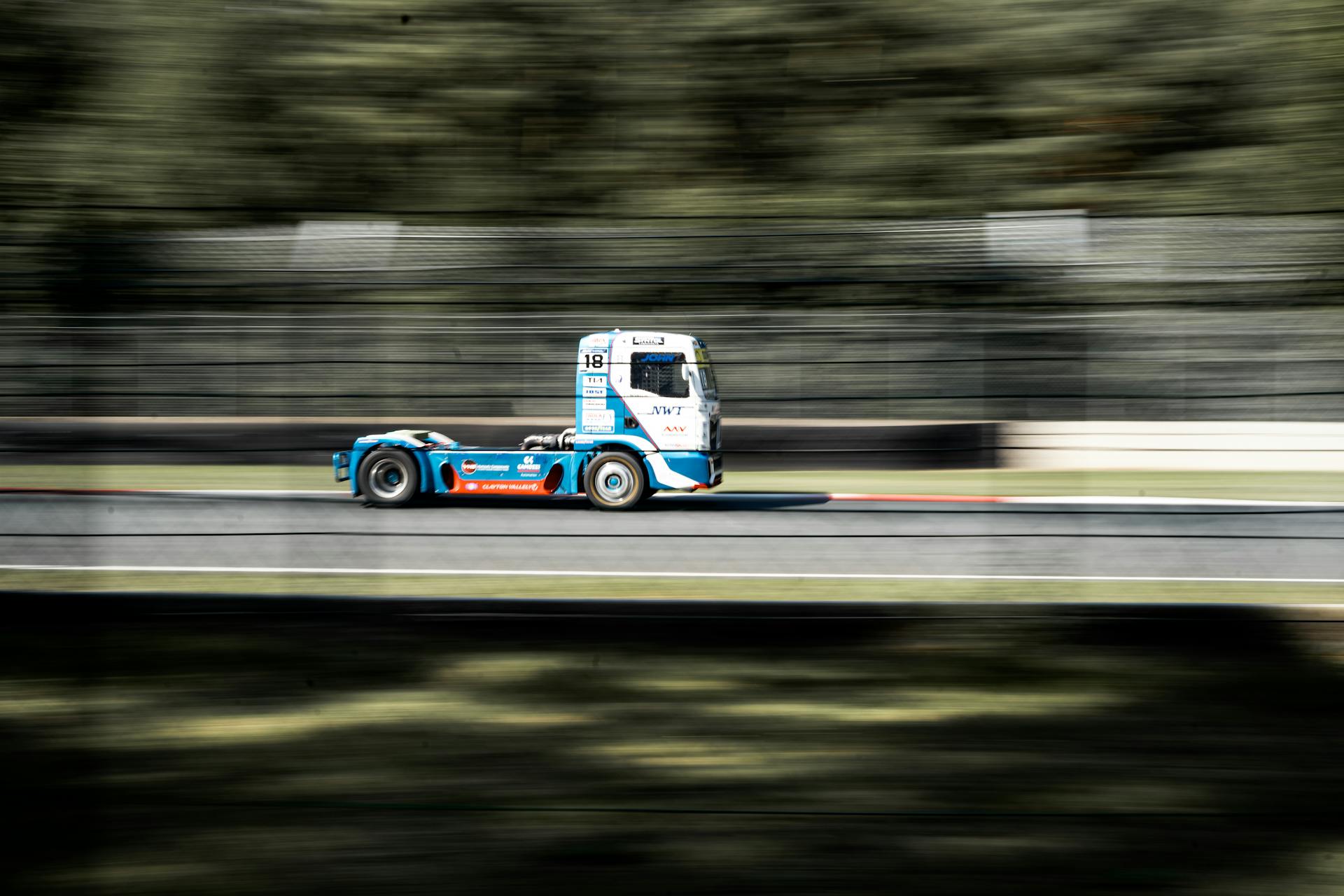 Dynamic image of a truck in motion on a racing circuit, showcasing speed and precision.