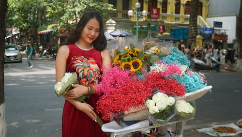 Woman in Red Dress Standing by Colorful Flowers