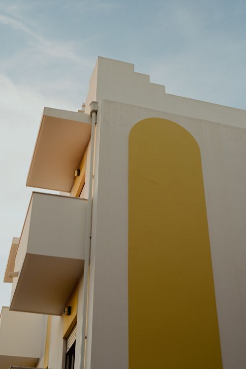 Free A modern residential building with geometric design and balconies against a clear sky. Stock Photo