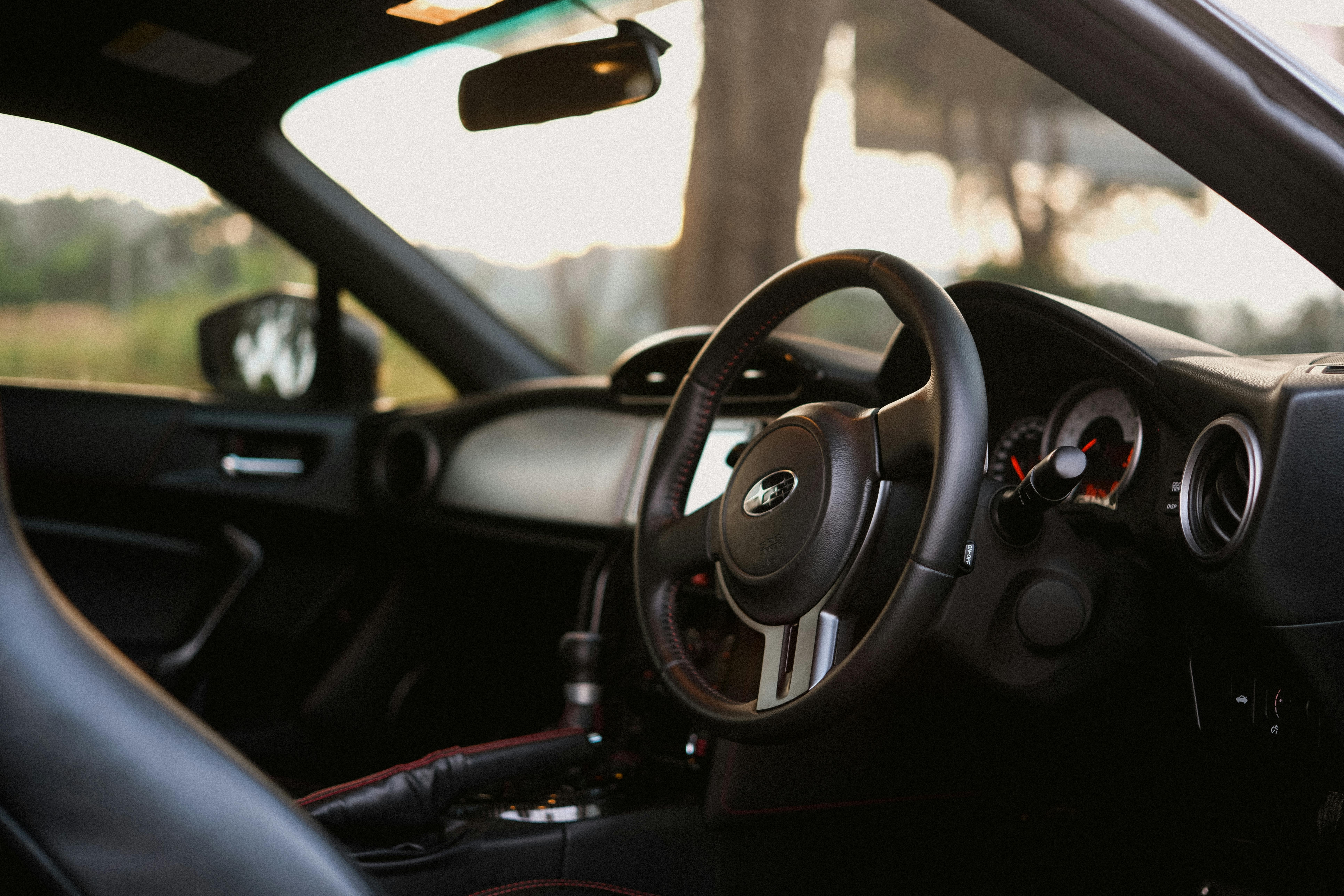 A detailed close-up of a modern car interior featuring a steering wheel, dashboard, and controls.