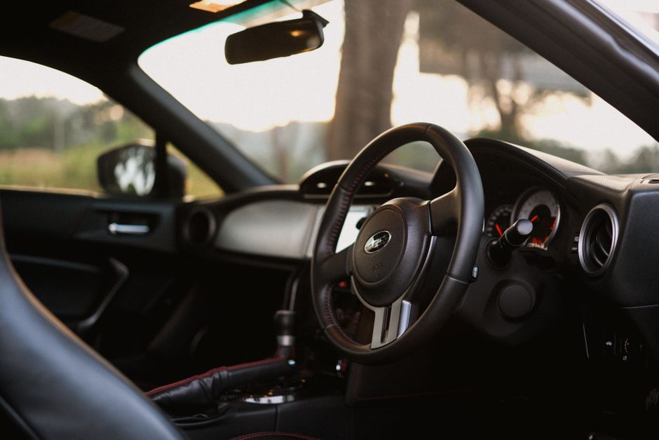 A detailed close-up of a modern car interior featuring a steering wheel, dashboard, and controls.
