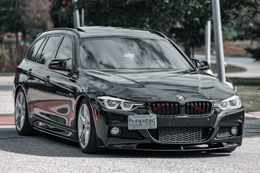 Luxury black sedan with sleek design parked on a city street during daytime.