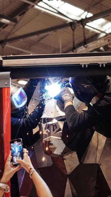 Two workers welding metal indoors, showcasing industrial craftsmanship in Essen, Germany.
