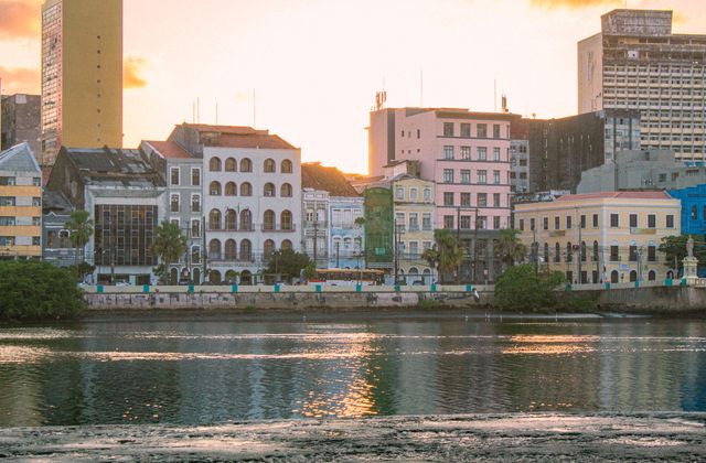 Beautiful sunset view of Recife's historic riverside architecture reflecting on the water. — arriving in Recife