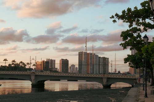 Clouds over an Urban Skyline at Dusk with a Bridge in the Foreground