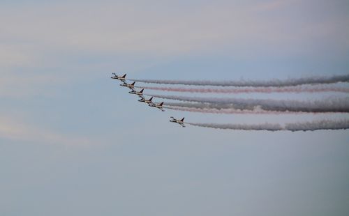 Free Military aircraft in formation flying, creating colorful vapor trails against a clear sky. Stock Photo