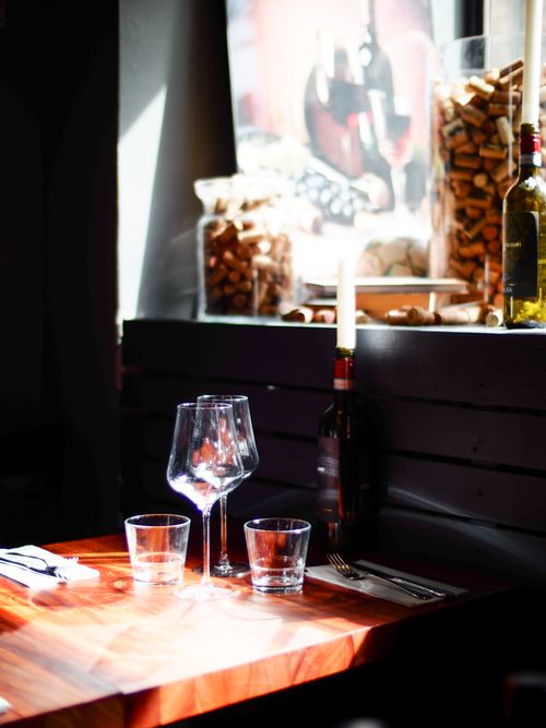 Free Sunlit restaurant table with wine glasses and bottle in Helsinki, Finland. Stock Photo