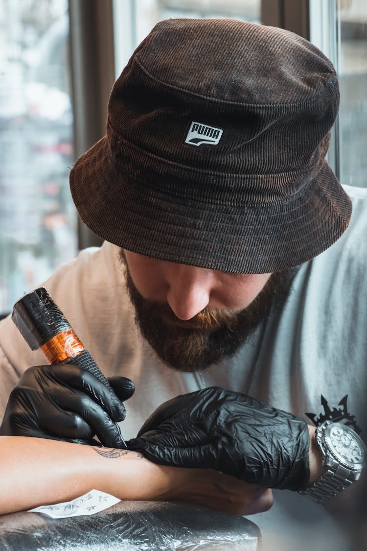 Tattoo Artist In Hat Working