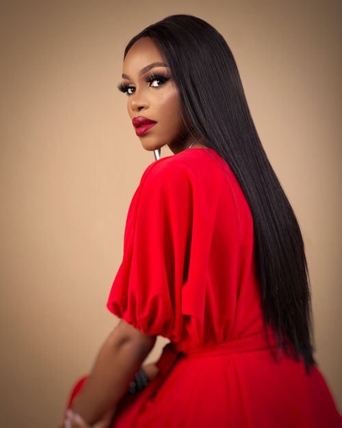 Free Striking portrait of a woman in a vibrant red dress with long black hair in a studio setting. Stock Photo