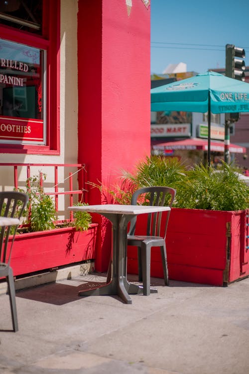 Table and Chair on Sidewalk in Front of Restaurant 