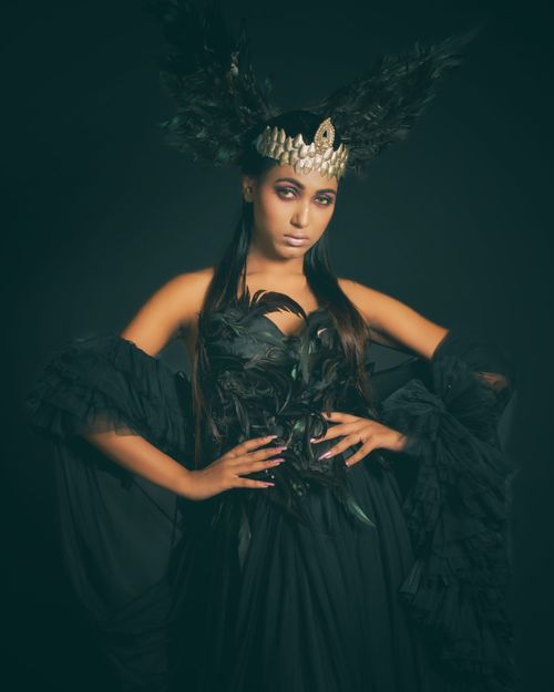 Free Striking portrait of a woman in an elegant black feathered costume with a crown, exuding fantasy and charm. Stock Photo