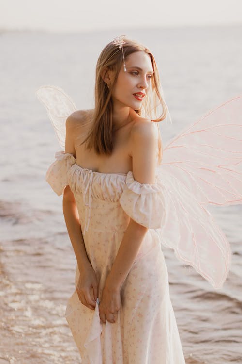 Portrait of Woman in Dress with Wings on Sea Shore