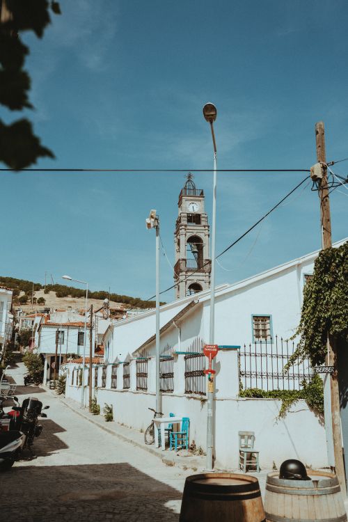 Free Discover a picturesque town with a historic bell tower under a clear summer sky. Stock Photo