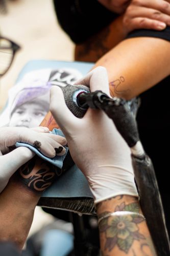 Hände mit Tattoomaschine, Nahaufnahme