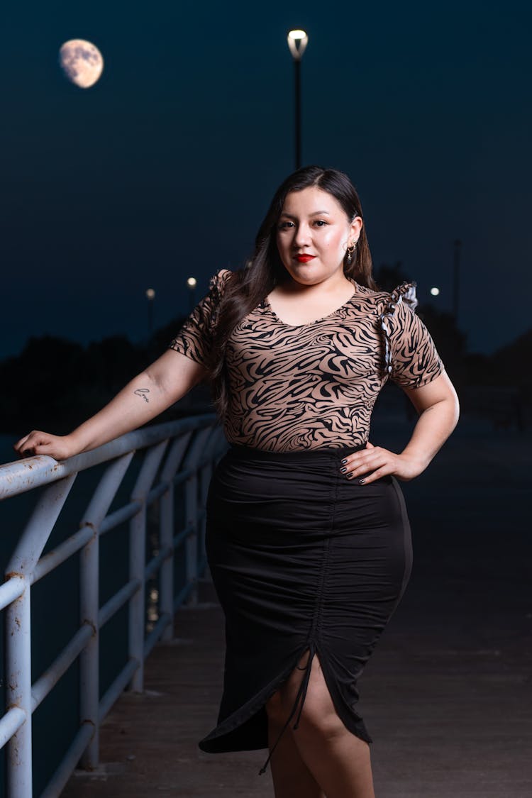 Beautiful Brunette Woman In Skirt Posing By Railing