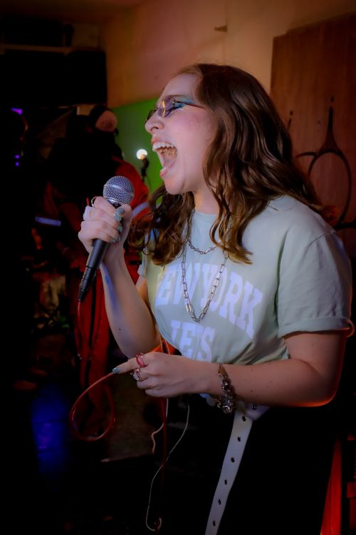 Free Young woman singing passionately in a vibrant nightclub setting in Mexico City. Stock Photo