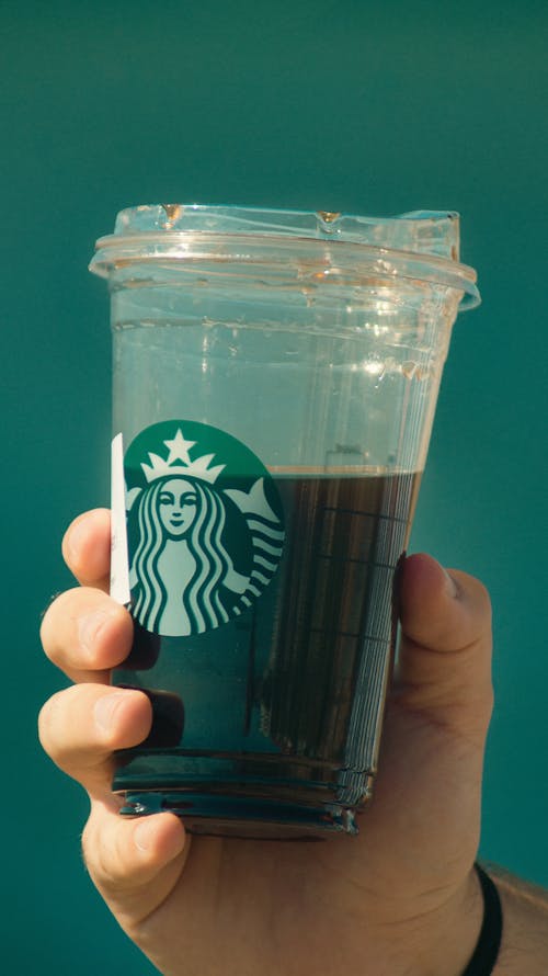 Close-up of a Person Holding a Coffee in a Starbucks Plastic Cup