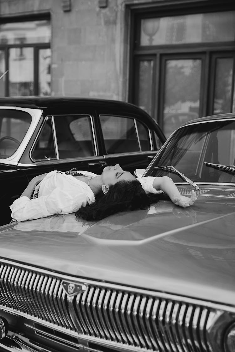 Woman Lying On The Hood Of A Vintage Car