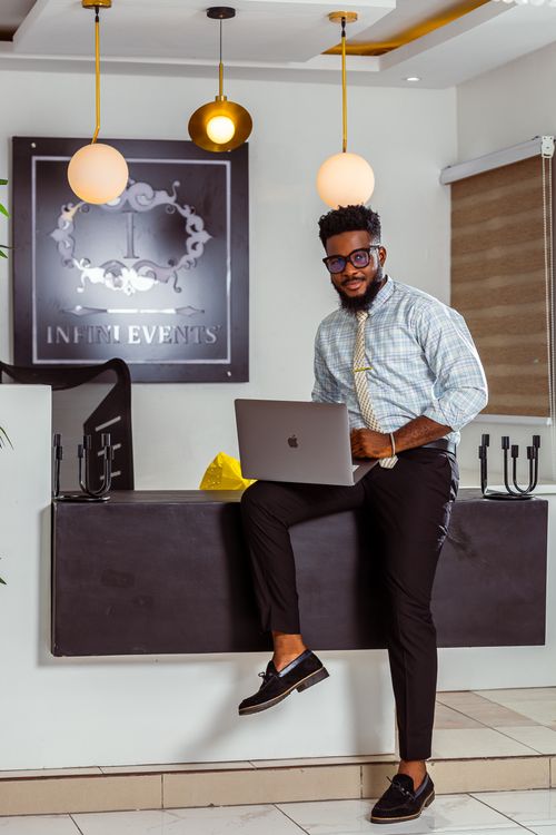 Free Confident young man in a stylish office, using a laptop and smiling. Stock Photo