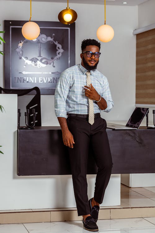 Man in a Blue Checkered Shirt with a Striped Tie and Black Pants with Crease at the Office Reception