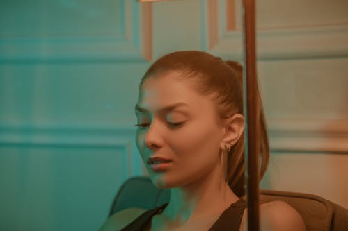 Young Woman Sitting on a Chair Photographed in Split Light