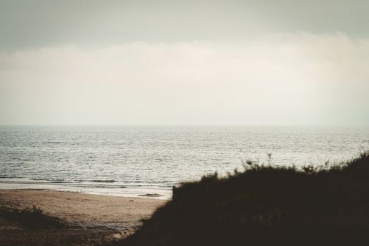 Tranquil beach scene in Liepāja, Latvia, with calm sea and sandy shore.
