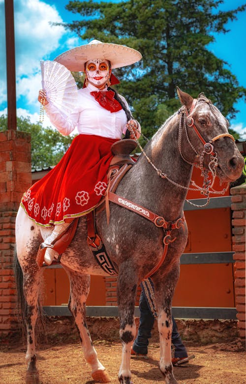 Woman in Sombrero and Traditional Clothing Sitting on Horse