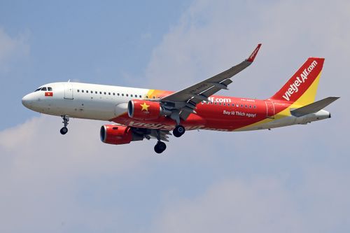 Free A VietJet Air Airbus A320 captured mid-flight against a clear sky, showcasing vibrant branding. Stock Photo
