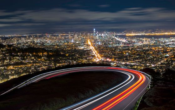 A breathtaking aerial view of San Francisco's illuminated skyline with light trails and urban landscape at night.
