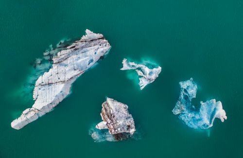 Free Stunning aerial shot of majestic icebergs floating in turquoise waters. Stock Photo