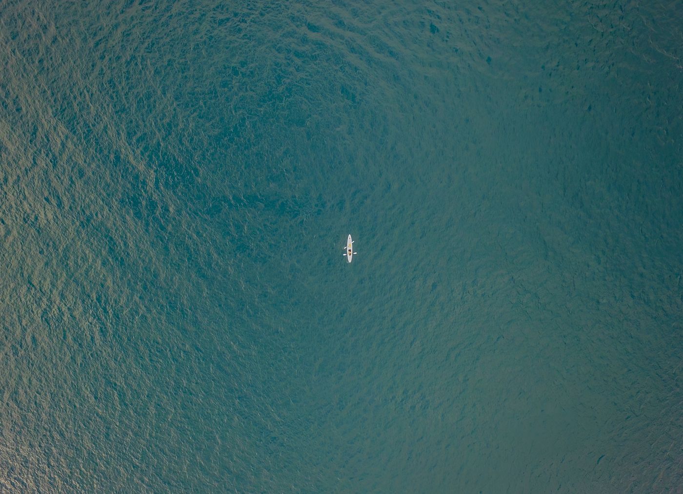 Aerial view of a kayaker crossing clear open ocean