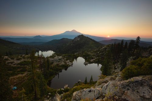 Free A breathtaking view of mountains, lakes, and forests at sunrise, capturing the tranquility of nature. Stock Photo