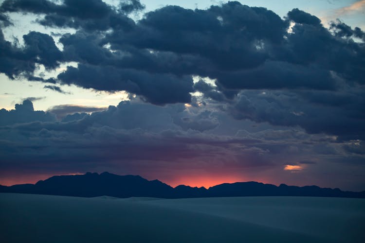 Clouds Over Mountains Silhouette At Dusk