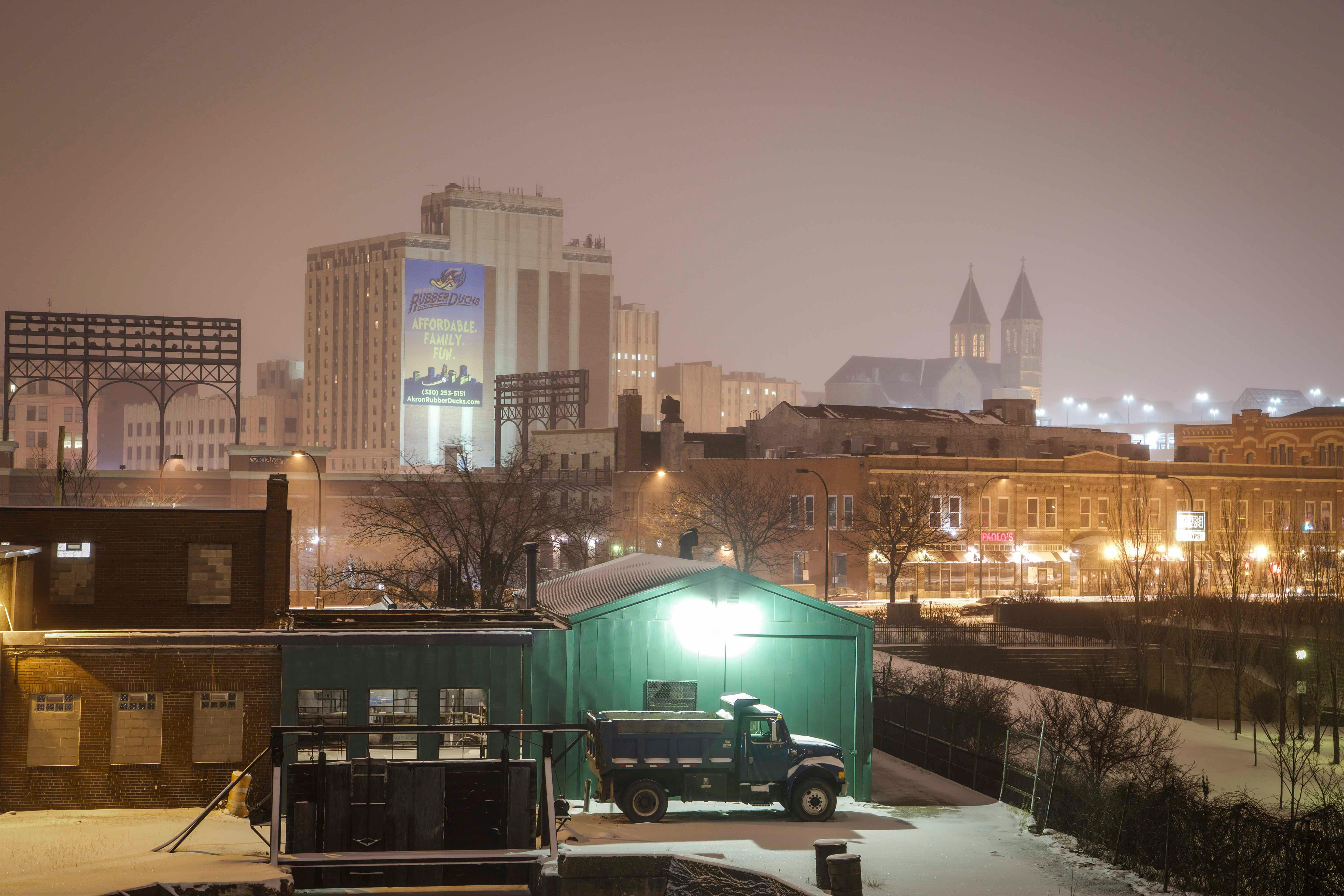 Cityscape at night with buildings and snow-covered streets, showcasing urban tranquility.