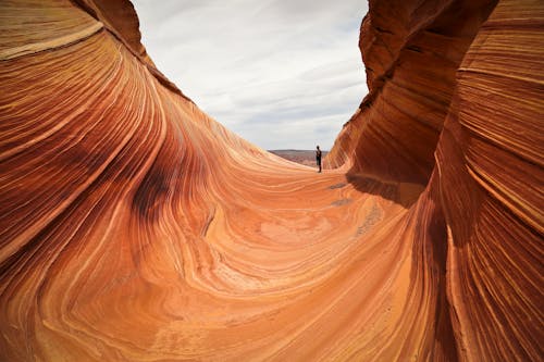 Man Standing among Rock Formations on Desert