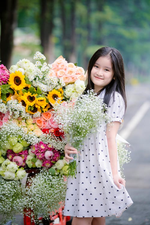 A Girl Standing next to a Flower Arrangement