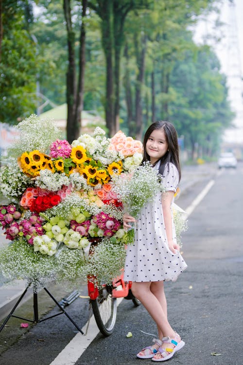 Teenager Girl Posing with a Heap of Flower Bouquets at a Roadside