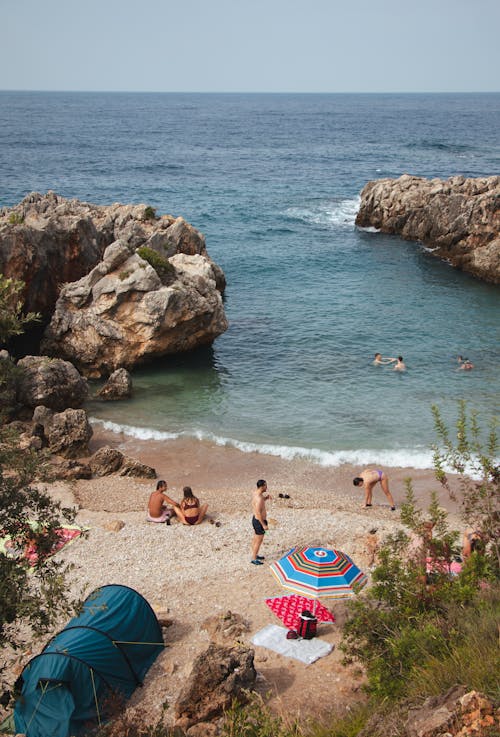 People Sunbathing and Swimming in the Sea