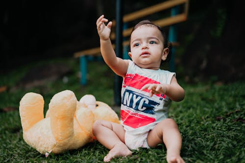 Baby Boy Sitting near Teddy Bear