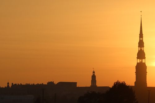 Free Silhouette of St. Peter's Church in Riga set against a warm sunset sky. Stock Photo
