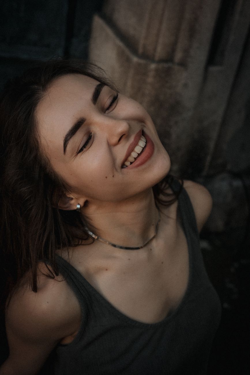 Close-up portrait of a smiling woman with closed eyes, exuding happiness.