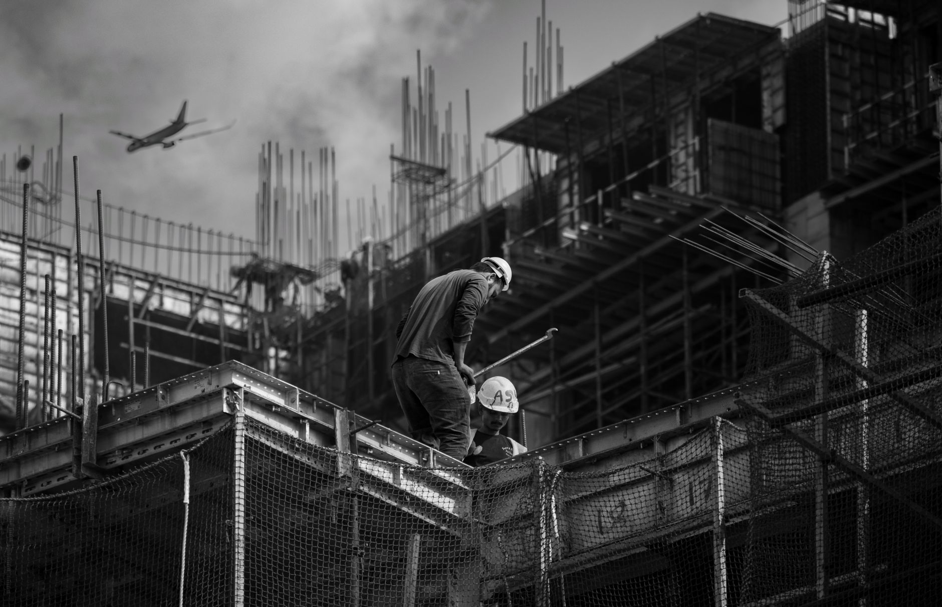 Black and white photo showing construction workers on an urban building site.
