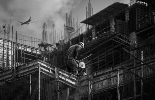 Black and white photo showing construction workers on an urban building site.