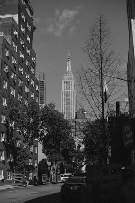 Monochrome view of the Empire State Building from a city street in New York City.