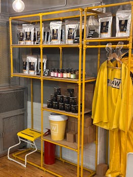 Colorful industrial interior showcasing coffee merchandise and apparel on yellow shelving units.