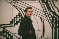 时尚男模特在户外独特的黑白壁画旁摆姿势