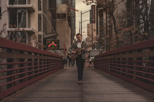 Man Playing Guitar in Footbridge