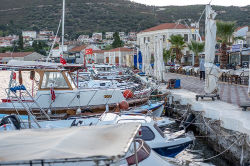 Free Charming coastal marina in Foça, İzmir with boats and vibrant waterside cafes. Stock Photo