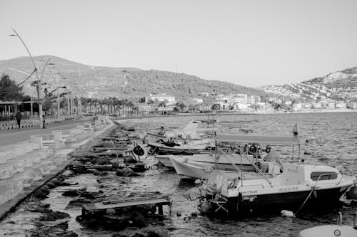 Motorboats Moored on Shore in Town in Black and White